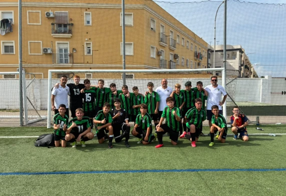 Fotografía de los jugadores y técnicos del Infantil reunidos sobre el césped después de un partido